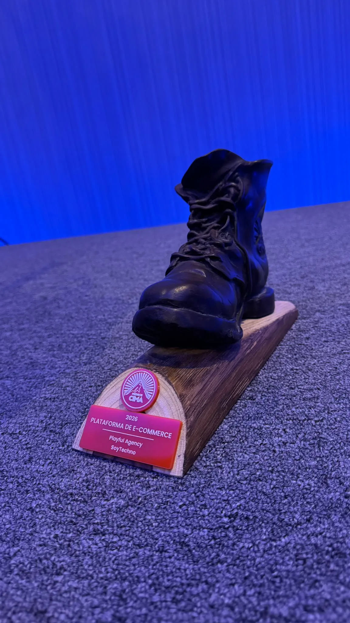 El trofeo de los Premios CIMA 2026 en la categoría Plataforma de E-commerce, con los nombres de SoyTechno y Playful Agency en la placa.
