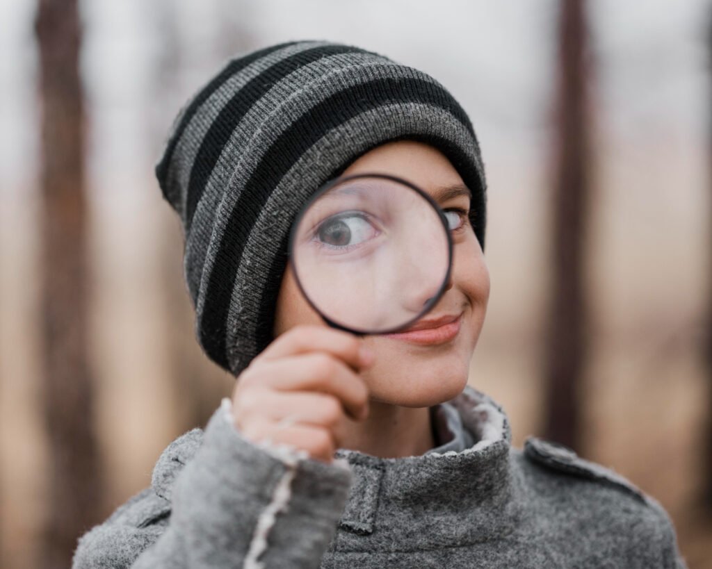 niño joven con lupa sobre el ojo, buscando conocimiento sobre inteligencia artificial
